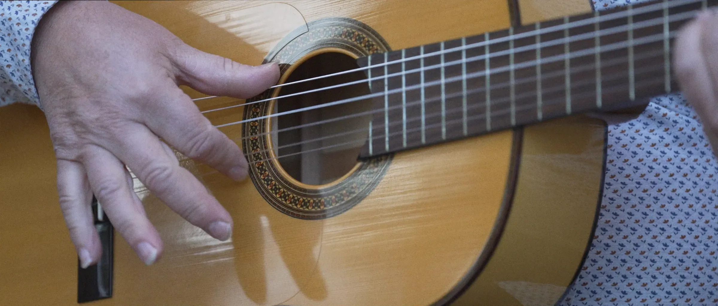 Las manos de un guitarrista tocando una guitarra española, en un fotograma de «Cartaya suena así», un vídeo de Bis